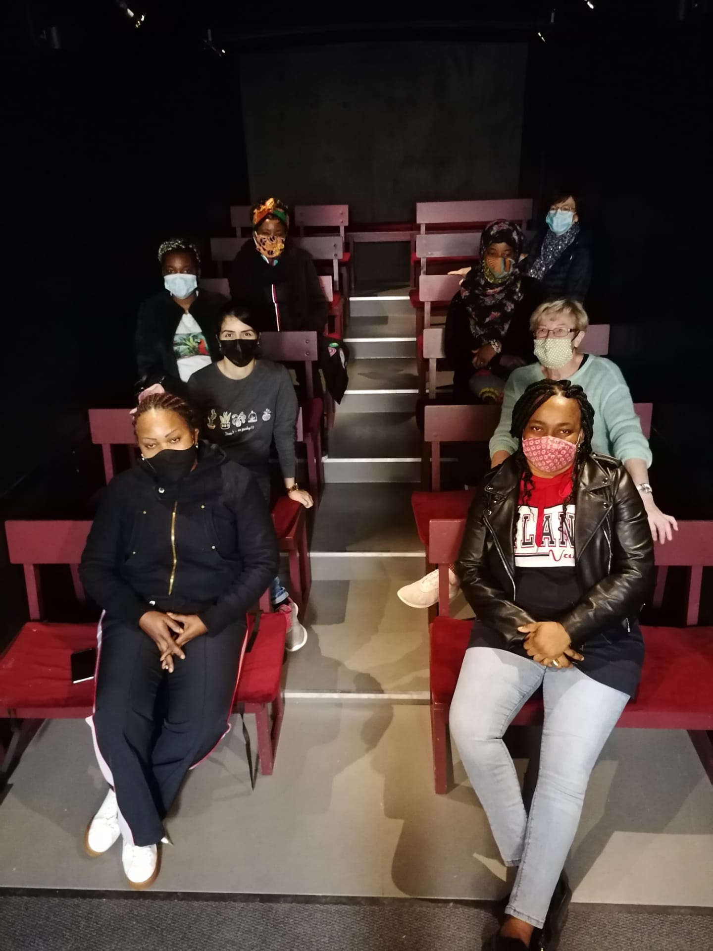 Les membres de l'asbl Atemos assis sur des gradins.